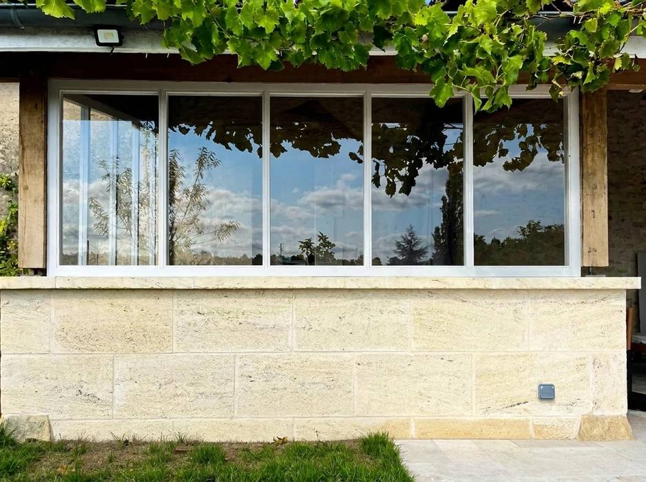 Façade extérieure d'une maison en pierre de taille calcaire beige