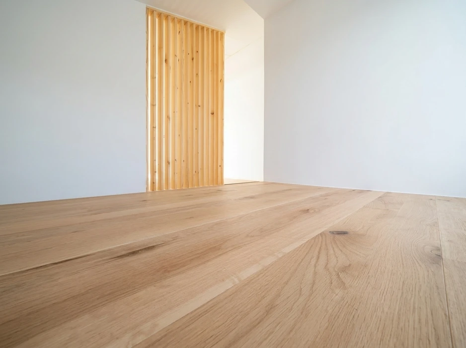 Pièce vide minimaliste, sol en parquet chêne massif blanc huilé, larges lames brutes aux veines apparentes